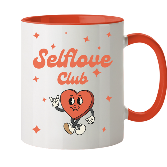 Weiße Tasse, Innenseite sowie Henkel Orange. Motiv: fröhliches rotes Comic Herz. Dazu der Schriftzug: Selflove Club